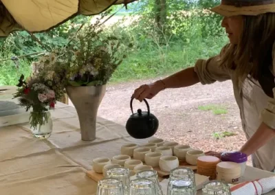 A lady serving tea at a camp lunch